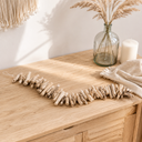 Treibholzkette im Raum — Sideboard mit Läufer, Glasvase und Kerzen vor heller Wand